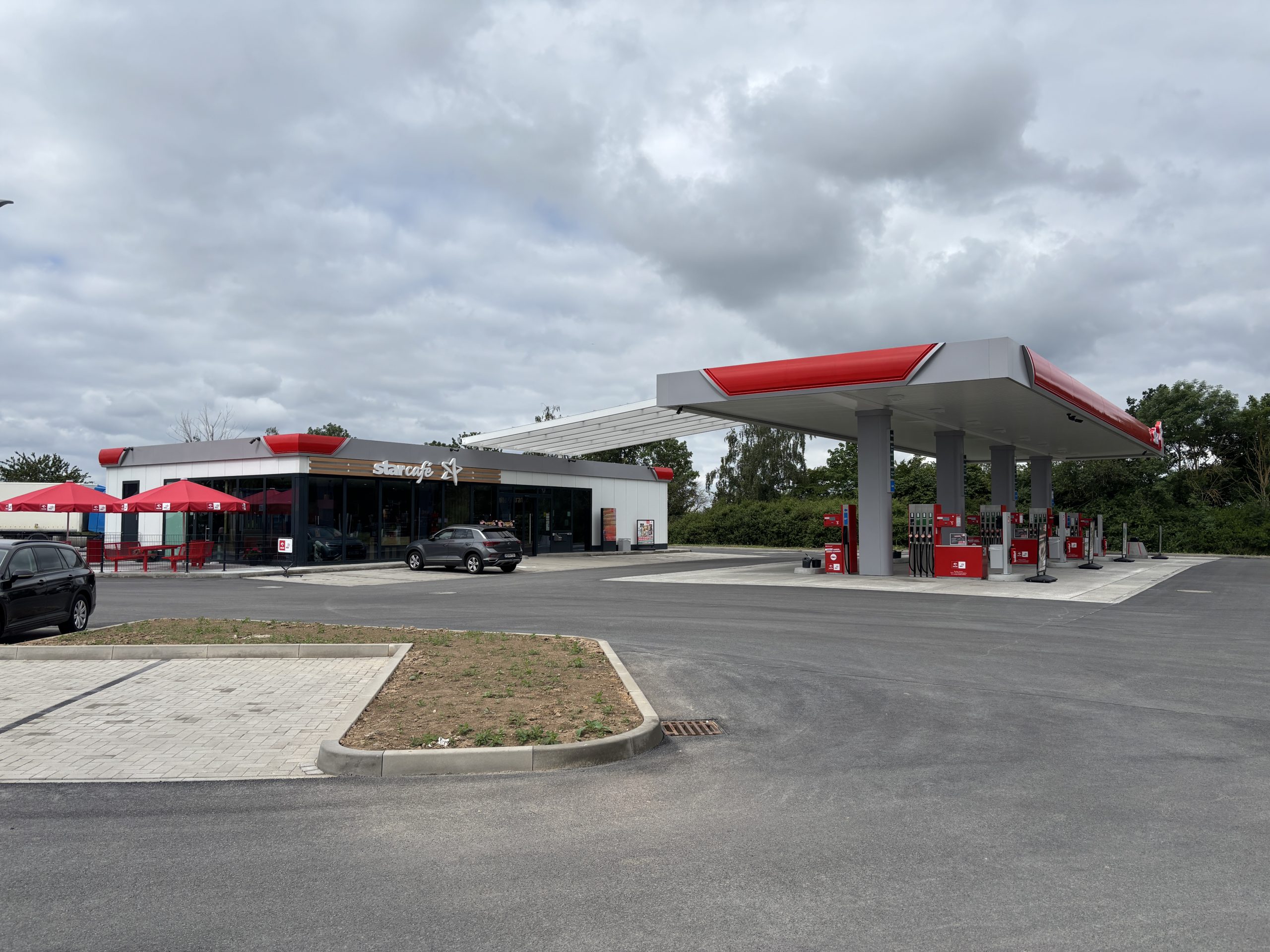 Einfahrt zur Orlen/Star Tankstelle mit Tankplätzen und einem Shopgebäude mit Café